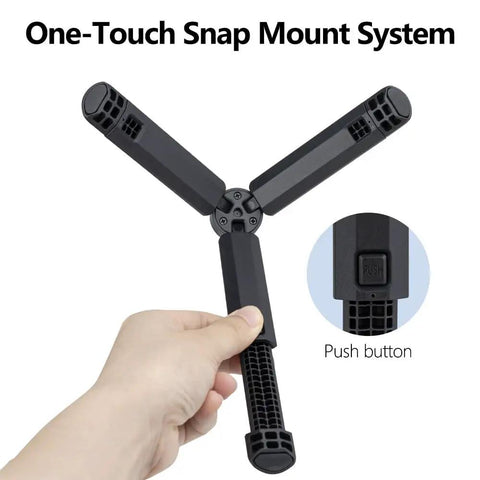 Hand holding Pocket Sized 2 In 1 Mini Tripod Desk Stand And Handheld Grip with one-touch snap mount system, black legs shown.