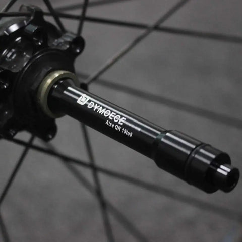 Close-up of Front 15mm Thru Axle to 9mm Quick Release Skewer Adapter on wheel hub, aluminum alloy, anodized black finish.