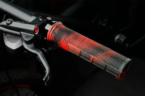 Red and black lock-on mountain bike handlebar grip with half-waffle pattern.