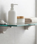 Glass shelf mounted with 4 Pack Zinc Alloy Brushed Duckbill Glass Shelf Clamps, holding bathroom items.