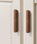Walnut Wood Drawer Pulls Set Six Pack 5.04 Inch Length With Rounded Edge For Cabinets; two walnut pulls on white cabinet doors