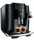 Next Level 5th Gen Automatic Smart Coffee Machine Bundle Featuring Piano Black Finish Plus Matching Glass Milk Frothing Container For Hella Smooth Lattes Bold Espresso And Quick Cappuccino Prep with two espresso shots in glasses.