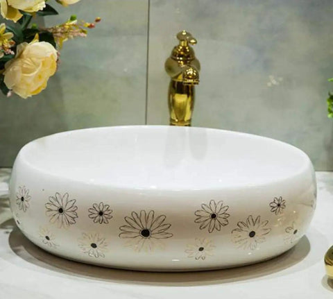 Slick Ceramic Oval Vessel Sink For Modern Bathroom Counters Smooth Glazed Finish with floral designs and gold faucet.