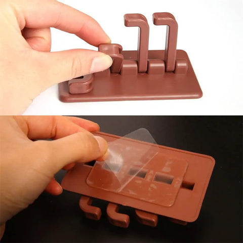 Hand demonstrating installation of Slick Rotary Sticky Hook Wall Mount With Heavy Duty Adhesive Grip for keys and coats.