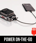 Badass Brushless 12 Volt Reciprocating Saw Kit With Quick Charge Battery connected to a smartphone for charging.