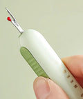 Hand holding a 3 Pack 2 In 1 Needle Threader And Seam Ripper Set For Sewing Threading And Seam Removal Must Have Handy Tool.
