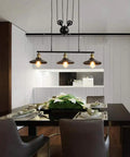 Fresh Vintage Industrial Billiard Chandelier Features Easily Adjustable Pulley Lift System In Classic Black Metal Three Light Ceiling Hanging Lamp above a dining table.
