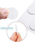 Close-up of self-adhesive screw hole covers showing ultra-thin white PVC stickers, highlighting texture and thickness.