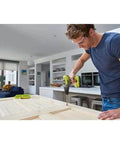 Heavy Duty 18V Cordless Drill With 50 Nm Torque And Dual Speed Settings Featuring A Rock Solid 13 Mm Keyless Chuck Built In Led Work Light And Hella Smooth 31 Piece Screwdriver Bit Kit For Top Notch Home Projects And Fast DIY Fixes used by a man assembling wood in a modern kitchen.