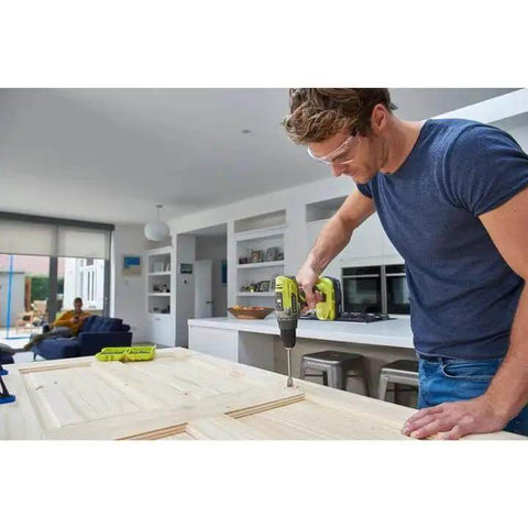 Heavy Duty 18V Cordless Drill With 50 Nm Torque And Dual Speed Settings Featuring A Rock Solid 13 Mm Keyless Chuck Built In Led Work Light And Hella Smooth 31 Piece Screwdriver Bit Kit For Top Notch Home Projects And Fast DIY Fixes used by a man assembling wood in a modern kitchen.