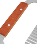 Close-up of wooden-handle crinkle cutter with stainless steel wavy blade, kitchen tool