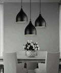 Dark Antique Farmhouse Pendant Light with Single Hanging Shade featuring three black suspended shades above a dining table.