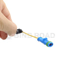 Close-up of blue brake pad wear sensor connector with yellow wires held in hand