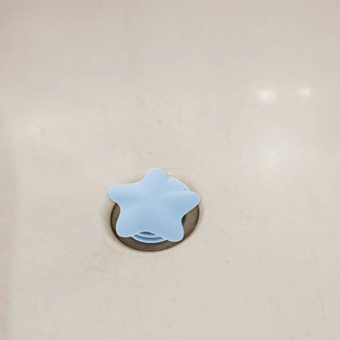 2pcs Silicone Bathtub Drain Stopper Flat Cover Shaped in star shape, blue silicone covering drain in a bathtub.