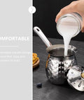 Pouring milk into Turkish Coffee Pot Cezve Ibrik 200ml Stainless Steel Stove Top Brewer With Spout and lid on countertop