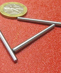 Heavy Duty 18-8 Stainless Steel Taper Pin Set For Precision Machining, shown with a coin for size reference on a red surface