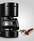 Compact Bean To Cup Coffee Machine And Espresso Maker With Reusable Filter, sleek black brewer with glass carafe and coffee grounds.