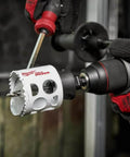 Milwaukee 2-1/2-inch ice-hardened hole saw mounted on a drill (side view)
