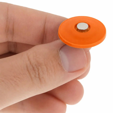 Resilient orange waterproof washer held between fingers for No Fuss Plastic Cap Nails Paired With Heavy Duty Electro Galvanized Ring Shank Fasteners And Resilient Orange Waterproof Washers For Fast Tar Paper And Roof Deck Work.