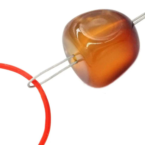 Close-up of Flexible 0.3mm Steel Wire Big Eye Embroidery Beading Needle Set Open End passing through a brown bead
