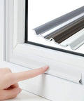 Self Adhesive T Shape Draft Stopper Tape Kills The Draft Seal Window And Door Gaps Block Noise No Sweat Weather Stripping Insulation Roll For Easy Install And Cozy Vibes White 118 Inches Long on a window frame.
