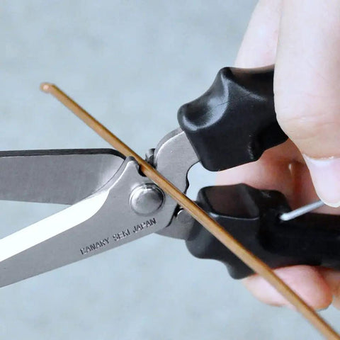 Close-up of Heavy Duty Beast Of A Carpet Cutter Tool 8 Inch Carpet Scissors cutting wire, featuring Japanese stainless steel blade.