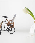 Killer Vintage Asian Rickshaw Driver Card Holder With Sleek Metal Body And Super Cool Rattan Detailing Perfect For Your Desk Or Shelves Bringing Fresh Home Office Energy To Your Space At Seven By Four Inches Wide on a minimalist background.