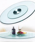 Twenty Seven Inch Tempered Glass Lazy Susan Round Kitchen Turntable Buttery Smooth Swivel Rotating Tray on dining table with decorative items.