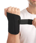 Person wearing black wrist brace for carpal tunnel relief, night sleep support for right or left hand, adjustable straps visible.