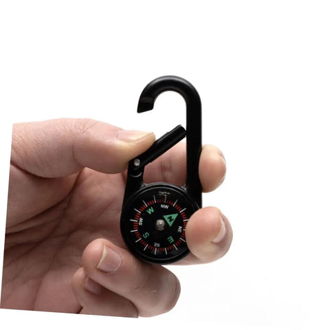 Hand holding Two Pack Outdoor Hiking Compass With Carabiner Keychain Go-To Pocket Navigation Tool in black.