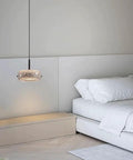Resin Pendant Light, Gold 3 Color LED Hanging Fixture for Living Room, crystal textured shade above a bed in a modern bedroom.