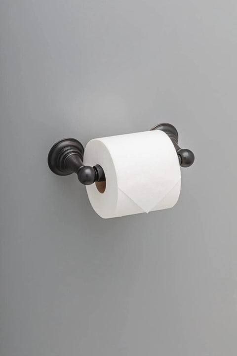 Providence Spring Toilet Paper Holder Wall Mounted With SpotShield Venetian Bronze Finish holding toilet roll on gray wall