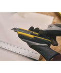 Person using FatMax Snap-Off Knife 18mm Heavy Duty Utility Knife with Rust-Resistant Stainless Barrel for precise cutting