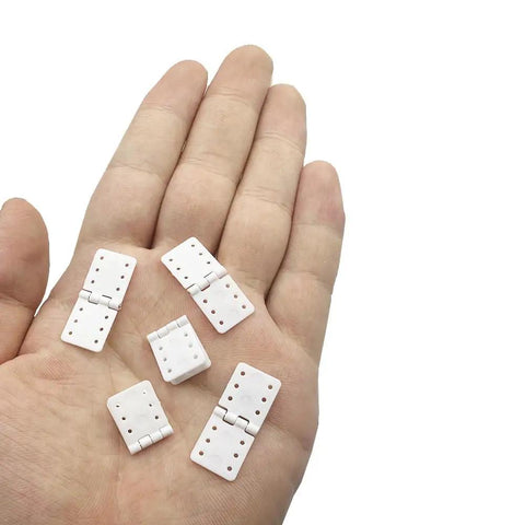 25 Pack Dope Nylon Pinned Hinges for RC Airplane Replacement Parts for Fixed Wing Models Small 12x24mm Durable Hinges With 6 Hole Sides For Strong Hold And Easy Glue In Install displayed on hand