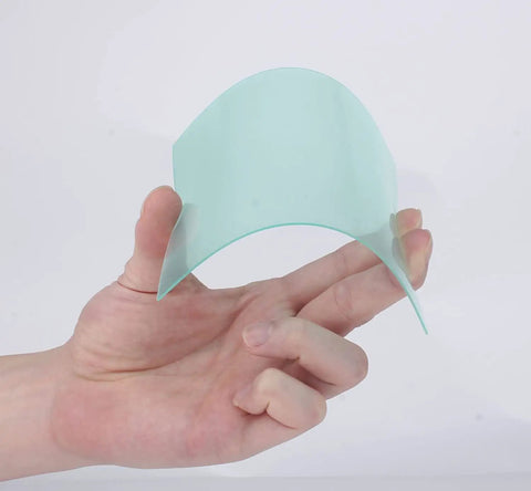 Person holding a curved piece of 1mm polycarbonate from Set of 20 Replacement Clear Lens Covers for Solar Auto Darkening Welding Helmets.