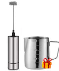 Handheld Battery Operated Milk Frother For Barista Quality Foam In Lattes And Cappuccinos, Mini Frappe Mixer next to a metal jug, Stainless Steel Silver, Quick Whip Foam At Home