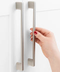 Close-up of hand holding Five Pack 7.5 Inch Hole Center Brushed Nickel Cabinet Pulls for cabinets, drawers, and vanities.