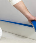 Blue Painters Tape With PaintBlock For Sharp Lines, 2 Inch Wide Painter Tape, used by person on wall, medium adhesion, clean removal up to 14 days