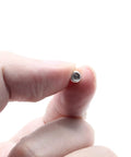 Close-up of a 50Pcs M5 X 4mm Cup Point Socket Set Screw Hex Allen Head Stainless Steel Grub Screw held between fingers.