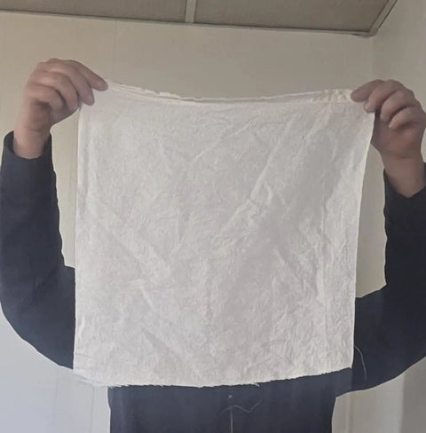 Person holding medical grade white cleaning rag lint free industrial shop towel for mechanics roofing painting