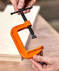 Beefy 1 Inch Heavy Duty Cast Iron G Clamp Quick Release For Woodworking And Welding Projects, Rugged Steel Clamp Fixture For Assembly, DIY Workshop, Hand Tool, Adjustable Screw, Non Slip Grip, High Load Capacity, orange G clamp held by hands