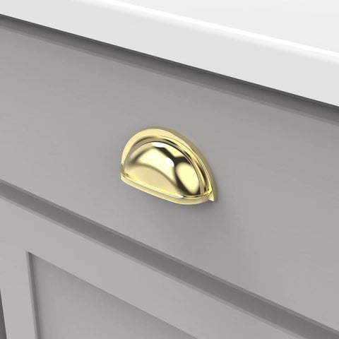 10 Pack Solid Core Polished Brass Cabinet Pulls 3 Inch Hole Center Kitchen Cup Handles on grey drawer front.