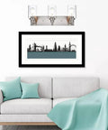 Dope Brushed Nickel Bathroom Light Fixture With Clear Glass Shade above framed art and sofa in living room