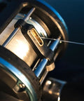 Tough As Nails Saltwater Level Wind Fishing Reel Size Thirty Featuring Graphite Housing Brass Main Gear showing line guide mechanism.