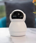 Top Tier 1080p AI Indoor Security Camera Featuring Sharp Human And Pet Motion Tracking Pan And Tilt Sweep For Effortless Home Crib Surveillance That Keeps Your Setup Locked Down Tight, white, compact design on a table.