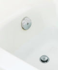 Chrome Touch Toe Tub Stopper Fits 2 Inch Cross Arm Drains With Adapters For Five Sixteenths And Three Eighths Inch Thread Sizes Hands Free Press To Close Or Open No Tools Required Bathroom Drain Accessory installed in a bathtub
