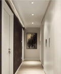 Narrow Frame LED Recessed Downlight illuminating a chic hotel corridor with dark walls and modern art.