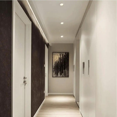 Narrow Frame LED Recessed Downlight illuminating a chic hotel corridor with dark walls and modern art.