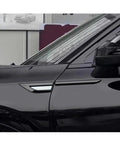 Glossy Side Fender Vents Trim Covers For Tesla Cybertruck shown on a black vehicle side panel, enhancing its sleek style.