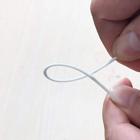 Person holding White PLA Filament 1.75mm 1kg for 3D Printing Tougher, Stronger FDM Material, showing flexibility.